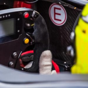 A driver holds the steering wheel of his supercar