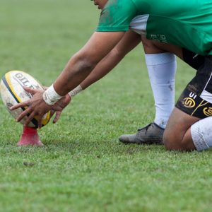 rugby player preparing to kick the oval ball during game