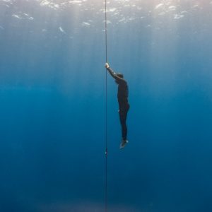 Free diver ascends to the surface by pulling the dive line