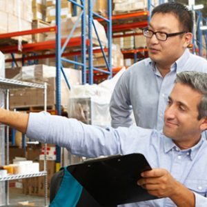 Business owner Working At Desk with employee in Warehouse